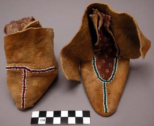 Pair of child's skin moccasins, decorated with beads and printed cotton cloth