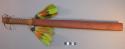 Wooden club with green feathers around the top - ceremonial