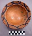 Red pottery bowl made on a wheel, with greenish - yellow glaze on inside