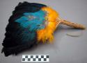 Fan - yellow, blue and irridescent feathers, wicker handle tied with +
