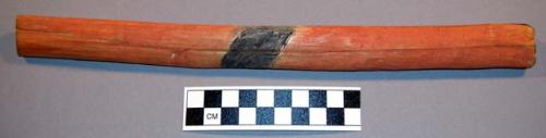 Dice stick. Wood painted red with a diagonal black band.