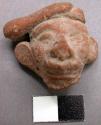 Pottery head, made from a mold, prominent ears. Height 3.4 cm.