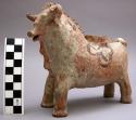 Modeled ceramic figurine of a bull. hollow with a hole in the center.