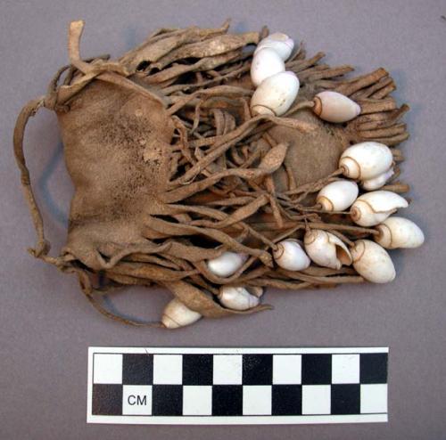 Zuni medicine bag and contents. Bag has fringe on all sides. Shells attached to