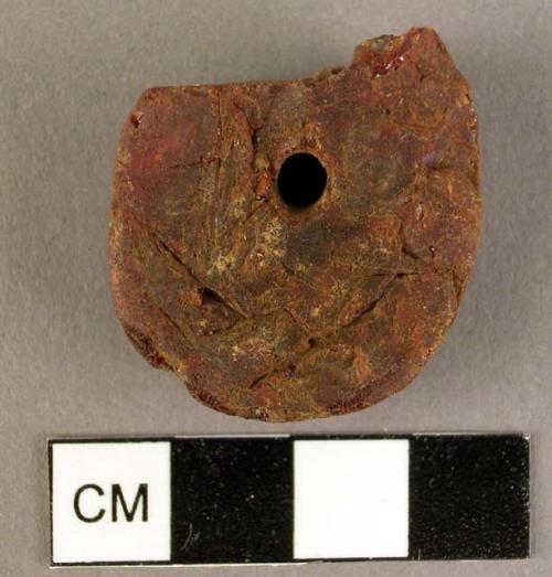 Fragmentary disk-shaped amber pendant, cross-drilled.