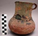 Polychrome pitcher painted and glazed decoration on upper half of red pottery.