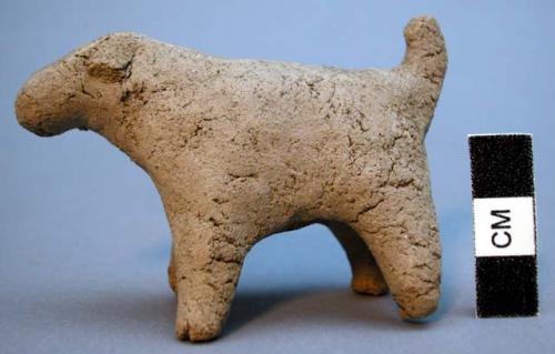 Unfired clay figurine depicting dog