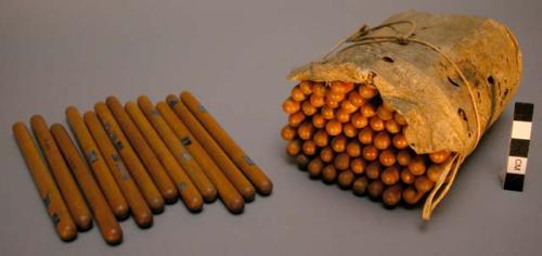 Deer skin bag holding set of maple gambling sticks