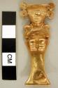 Human effigy of gold alloy.  Figure seated on elongated throne, with ear scrolls