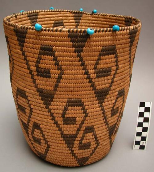 Cylindrical basket, coiled. Blue beads on rim. Geometric designs.
