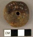 Disk-shaped amber pendant, cross drilled on the top, and flattened on the bottom