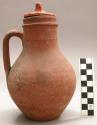 Red earthenware jug with incised rings around the neck.