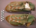 Pair of moccasins. Green buckskin uppers; rawhide sole. Yellow and white beadw