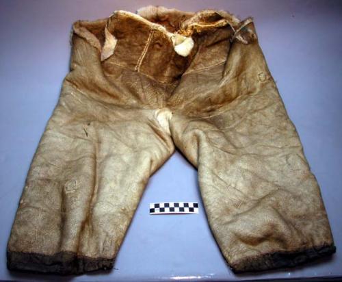 Pants, leather exterior, fur lined, sewn w/ sinew, drawstrings on legs, mended