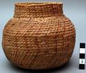 Jar-shaped basket, coiled. Geometric designs.