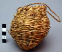 Small round basket of wrapped weave with braided handle