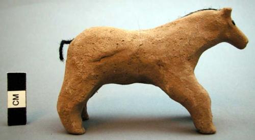 Unfired clay figurine depicting horse