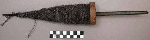 Wooden spindle (hand-driven) with spun wool on it