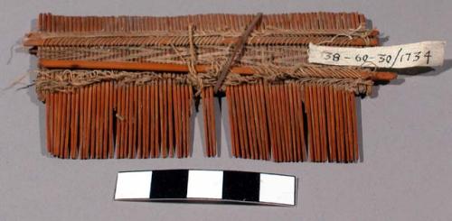 Wooden comb - teeth woven in place with thread; used by women