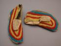 One pair of child's skin moccasins with bead decoration - red, yellow & blue ban