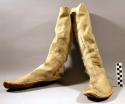 Pair of boots. Made from piece of leather sewn up at side. Rawhide sole