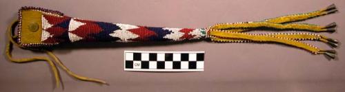 Beaded awl or scissors case--long and conical. Made of rawhide.