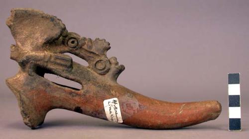 Tripod leg rattle with beak-bird holding human head.