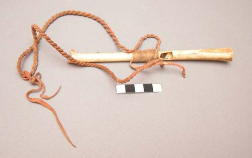 Crow eagle bone whistle. Ornamented w/ long twisted leather thong, red pigment