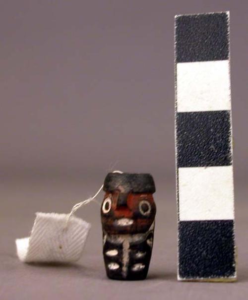 Ceramic tubular bead, human effigy, incised and painted