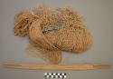 Fishing net in process of weaving with wooden bobbin and wooden sword +