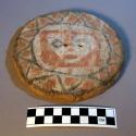 Painted wooden disc - crude face inside triangle design; colors, red, +