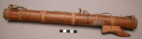 Flute, of wood with leather thongs tied around it and decorative appendage