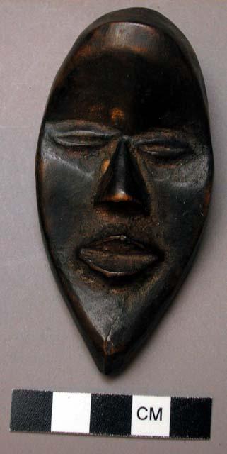 Small wooden mask - property of a man who prays to it for good luck and also sac