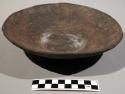 Clay food plate. black with incised lines on inside. made by women (ujuachu)