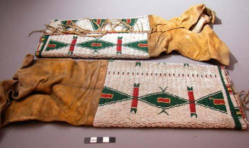 Pair of Sioux woman's leggings. Buckskin, bottom half covered w/ lazystitch