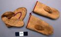 Miniature moccasin and pair of mittens, leather, stitched w/ red thread.  Originally attached to wampum belt.