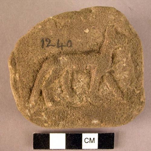 Fragment, sandstone, carved with jackal in relief