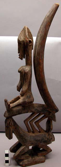 Ci Wara headdress in form of antelope with human figure seated at top, leaning