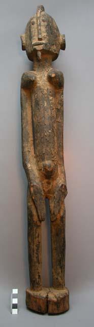 Standing long-armed female ancestor figure with chin plug, hands on loins; figur