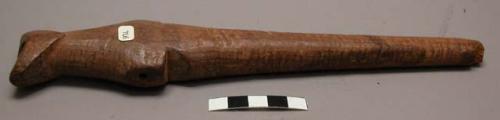 Carved wooden flute, 3 perforations, tapered at one end.