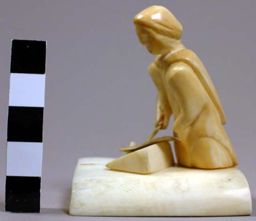 Ivory carving of woman scraping a skin