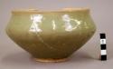 Grey ware bowl - heavy green glaze; faint pattern of conventional flowers inside, leaves outside;