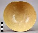 Deep white ware bowl - yellow glaze; ring-shaped bottom; flower design on inside
