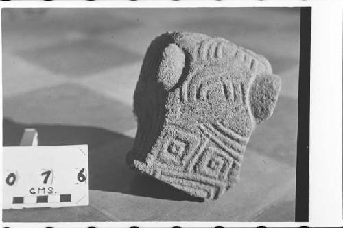 Fragment of stone head, with bas-relief