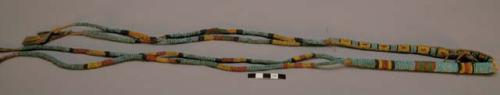 Arapaho needle case. Wrapped w/ glass seed beads. Decorated thongs