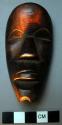 Small wooden mask - property of a man who prays to it for good luck and also sac