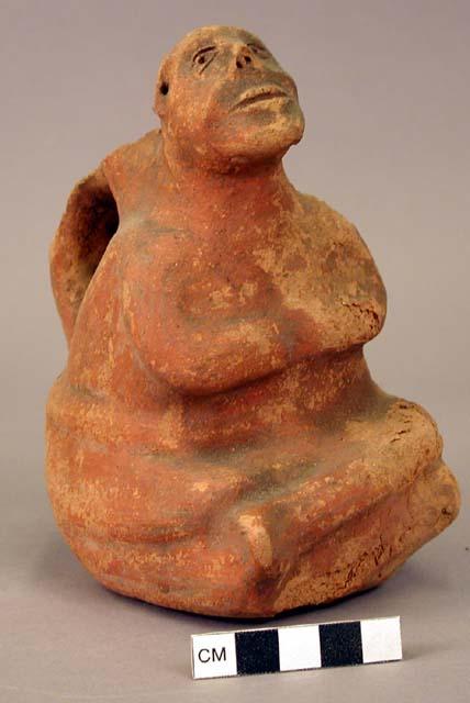 Ceramic bottle, human effigy, sitting crosslegged, arms crossed, molded face