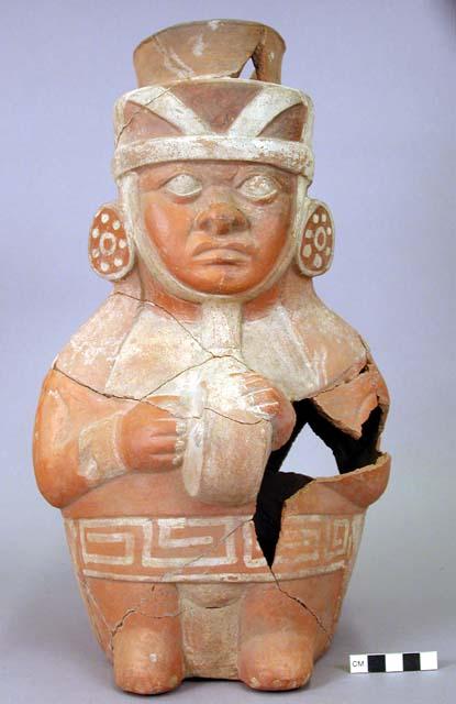 Ceramic jar,  moulded human face & arms, white on orange design, sherds missing