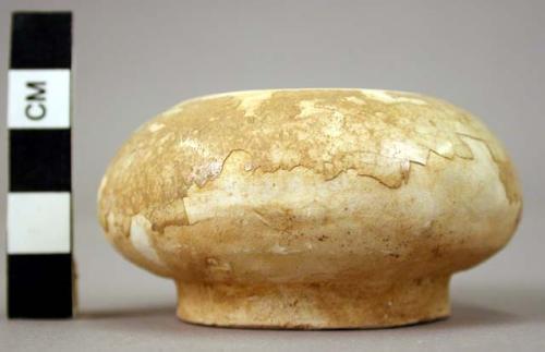 Very small white ware bowl - disc-shaped base; curving in toward rim; traces of glaze;
