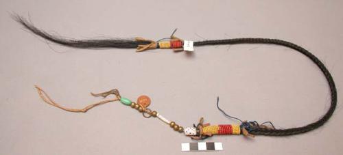 Blackfoot hair ornament. Braided horsehair w/ leather, beads, and metal ring.